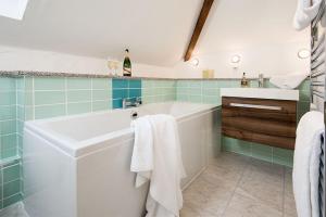 ein Badezimmer mit einer Badewanne und einem Waschbecken in der Unterkunft Gill Cottage, Castle Carrock, Nr Carlisle in Castle Carrock