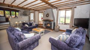 sala de estar con sofás, TV y chimenea en Mill Barn, Castle Carrock, Nr Carlisle en Castle Carrock