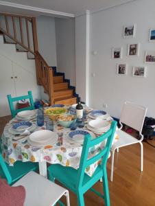 a dining room table with plates and bowls of food at Dúplex en Comillas in Comillas