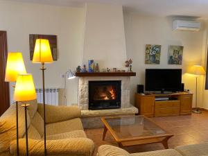 sala de estar con sofá y chimenea en CASA RURAL con Chimenea, Barbacoa, Terraza y Solarium, en Illar