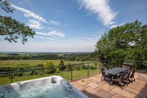 a hot tub on a patio with a table and chairs at Orchard House, Castle Carrock, Nr Carlisle in Castle Carrock