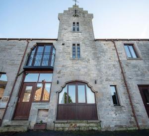 a building with a tower with a door and windows at Tower Barn Cottage, Castle Carrock, Nr Carlisle in Castle Carrock