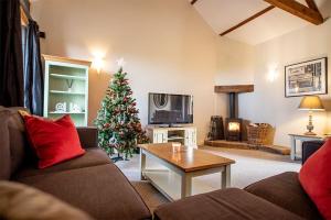 a living room with a christmas tree and a couch at Tower Barn Cottage, Castle Carrock, Nr Carlisle in Castle Carrock