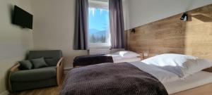 sypialnia z łóżkiem, krzesłem i oknem w obiekcie Apartament, Pokoje Koniczynka w mieście Karpacz