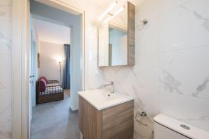 uma casa de banho branca com um lavatório e um espelho em #FLH - Nereus & Oceanus Beachfront Apartments, Lagonisi Beach em Ormos Panagias