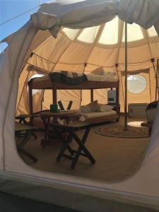 a tent with a bed and a table in it at Totoralillo Glamping in Coquimbo