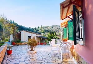 un patio con sedie e tavolo in un edificio di The Homey a Sidari