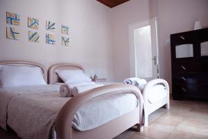 una camera da letto con un letto bianco e un animale di peluche di The Homey a Sidari