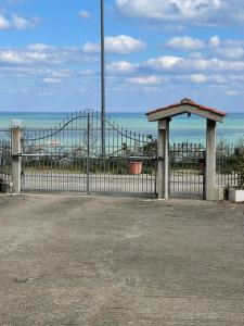 una recinzione con un cancello con l'oceano sullo sfondo di Villa Acquabella a Ortona