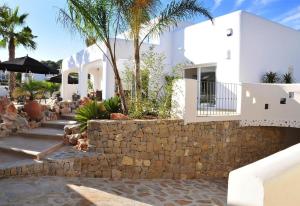 ein weißes Haus mit einer Steinmauer und Palmen in der Unterkunft Luxury Xenofilia V in Moraira