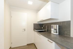 a kitchen with white cabinets and a counter top at Fewo Hafenblick in Kühlungsborn