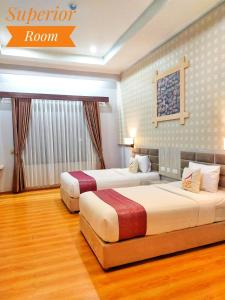 UNP Hotel & Convention في بادانج: سريرين في غرفة فندق مع