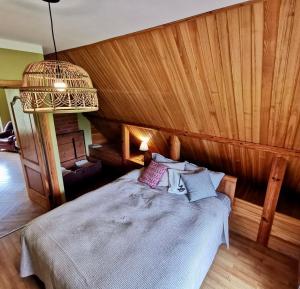 a bedroom with a bed with a wooden wall at Kastaņas in Kaibala