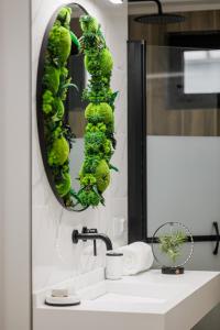 un bagno con una pianta verde su uno specchio di Bright House Cantemir a Bucarest Altre 19 foto