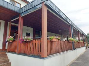 a building with potted plants on a balcony at Penzion Country Steak Restaurant in Lanškroun