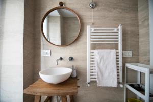 ein Badezimmer mit einem weißen Waschbecken und einem Spiegel in der Unterkunft Wi-Fi & NETFLIX - Luxe Suite nel Cuore di Salerno in Salerno