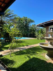 un patio con una fuente y una piscina en House 30 meters from the beach, en Guarujá