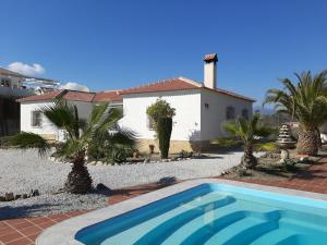 una villa con piscina di fronte a una casa di Casa de Las Rosas a Málaga