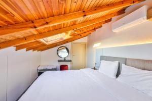 una camera con letto bianco e soffitti in legno di Tuğçe Apart a Kaş