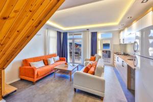 een woonkamer met oranje meubels en een keuken bij Tuğçe Apart in Kas