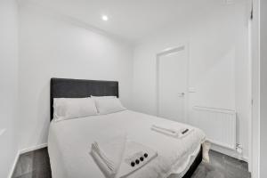 um quarto com uma cama branca e uma cabeceira preta em Grosvenor 3121 Richmond em Melbourne
