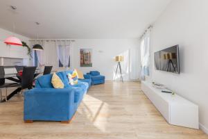Rialto Bridge Luxury apartment في البندقية: غرفة معيشة مع أريكة زرقاء وطاولة
