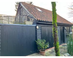 a house with a black fence and a black garage at Two Storey Annex in Cottenham