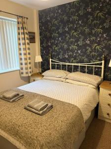 a bedroom with a bed with two towels on it at Fernhill Retreat in Charmouth