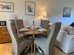 een eetkamer met een tafel, stoelen en een bank bij Fernhill Retreat in Charmouth +10 foto's