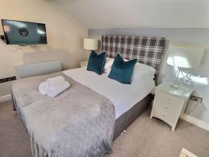 a bedroom with a large bed with blue pillows at Bootes Cottage in York