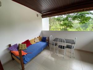 Habitación con cama, mesa y ventana en GREENHOUSE Hospedagem, en Macaé