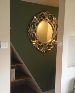 a gold mirror hanging on a wall in a room at Farmhouse B&B in Saint-Georges