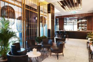 a restaurant with black chairs and tables and a bar at Hotel Reykjavík Saga in Reykjavík