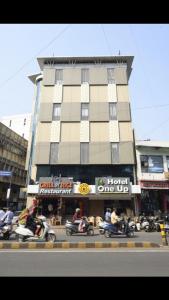 a group of people riding motorcycles in front of a building at Hotel One Up in Ahmedabad