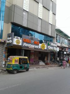 uma carrinha amarela e verde estacionada em frente a um edifício em Hotel One Up em Ahmedabad