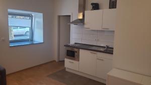a kitchen with white cabinets and a sink and a window at Apartment Nordbergstrasse in Heilbronn