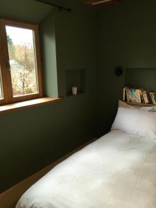 a bedroom with a white bed and a window at Farmhouse B&B in Saint-Georges