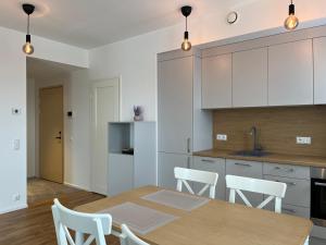 タルトゥにあるNature & Comfort City Stayのキッチン(木製テーブル、白いキャビネット付) +8枚の写真