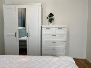 a bedroom with a white dresser and a closet at Nature & Comfort City Stay in Tartu