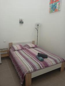 ein Bett mit zwei Kissen und einer Lampe darauf in der Unterkunft Le clos du pin in Thèzan-lès-Béziers