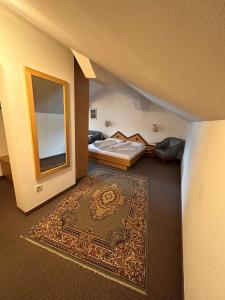 um quarto com uma cama, um espelho e um tapete em Hotel Brandl em San Candido