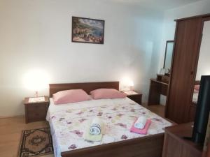 sypialnia z łóżkiem z różowymi poduszkami i lustrem w obiekcie Apartman Zlata w Ražancu
