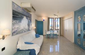 a living room with a white couch and blue chairs at L'incanto Di Boccadarno in Marina di Pisa