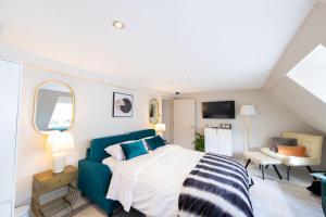 um quarto com uma cama e um sofá azul em Haus of Mason em Londres