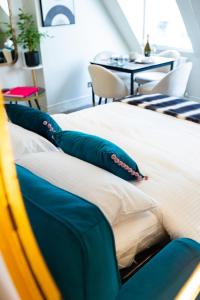 Una cama con almohadas azules y blancas y una mesa. en Haus of Mason en Londres