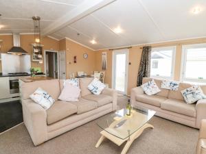 a living room with two couches and a table at Rosie's Chalet in Carlisle