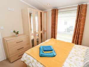 a bedroom with a bed with a blue towel on it at Rosie's Chalet in Carlisle