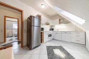 uma grande cozinha com um frigorífico de aço inoxidável em Privatapartment em Laatzen