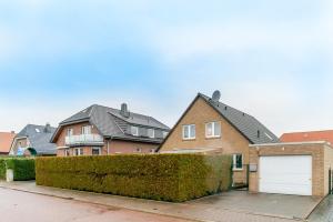 a row of houses with a driveway and a garage at Privatapartment in Laatzen