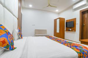 um quarto com uma cama e uma televisão em FabHotel Right Choice em Indore